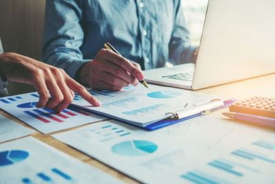 Hands pointing out statistics on a report