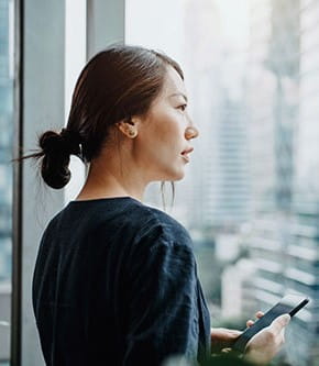 Woman looking out a window onto a city