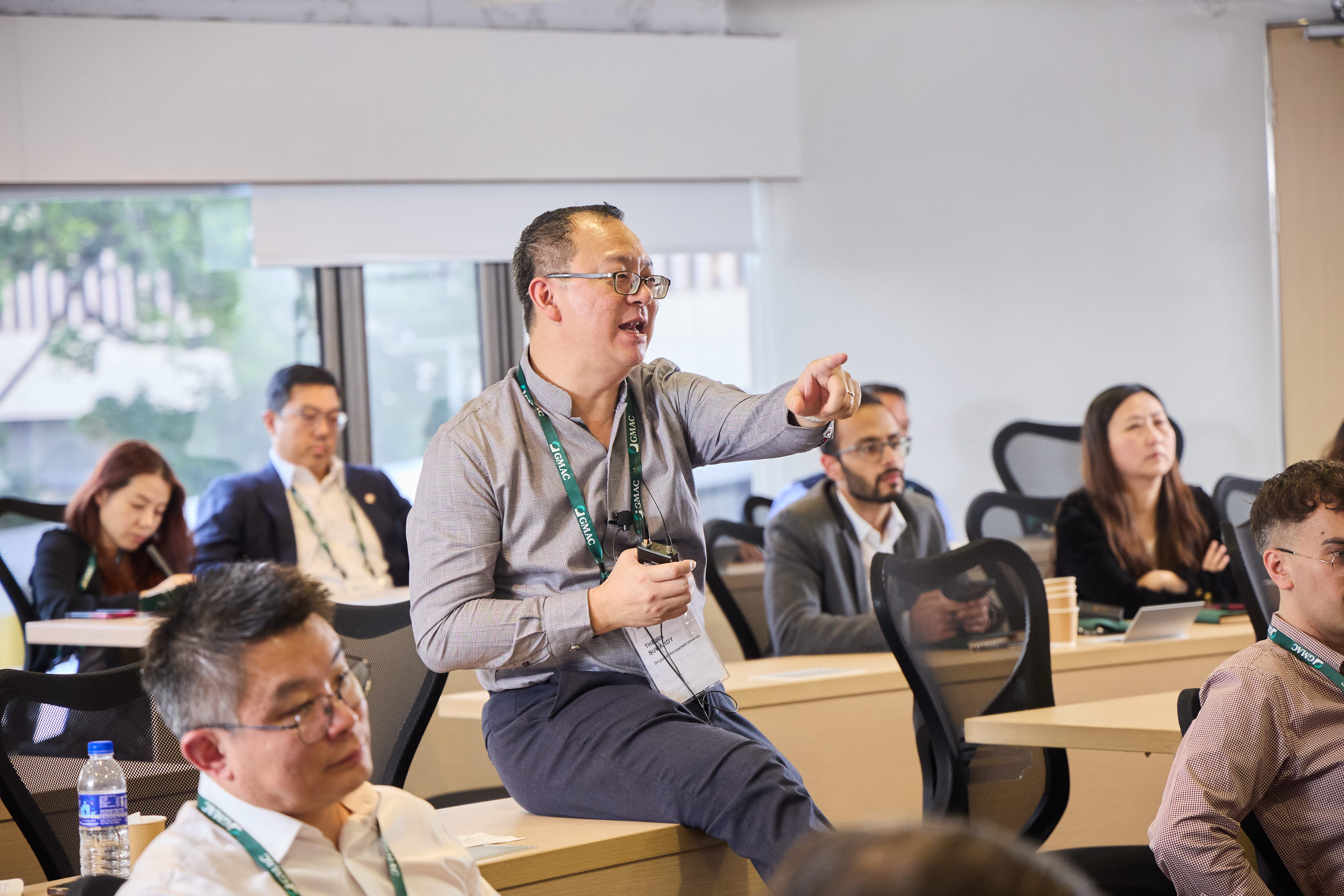 man speaking in front of large business meeting 