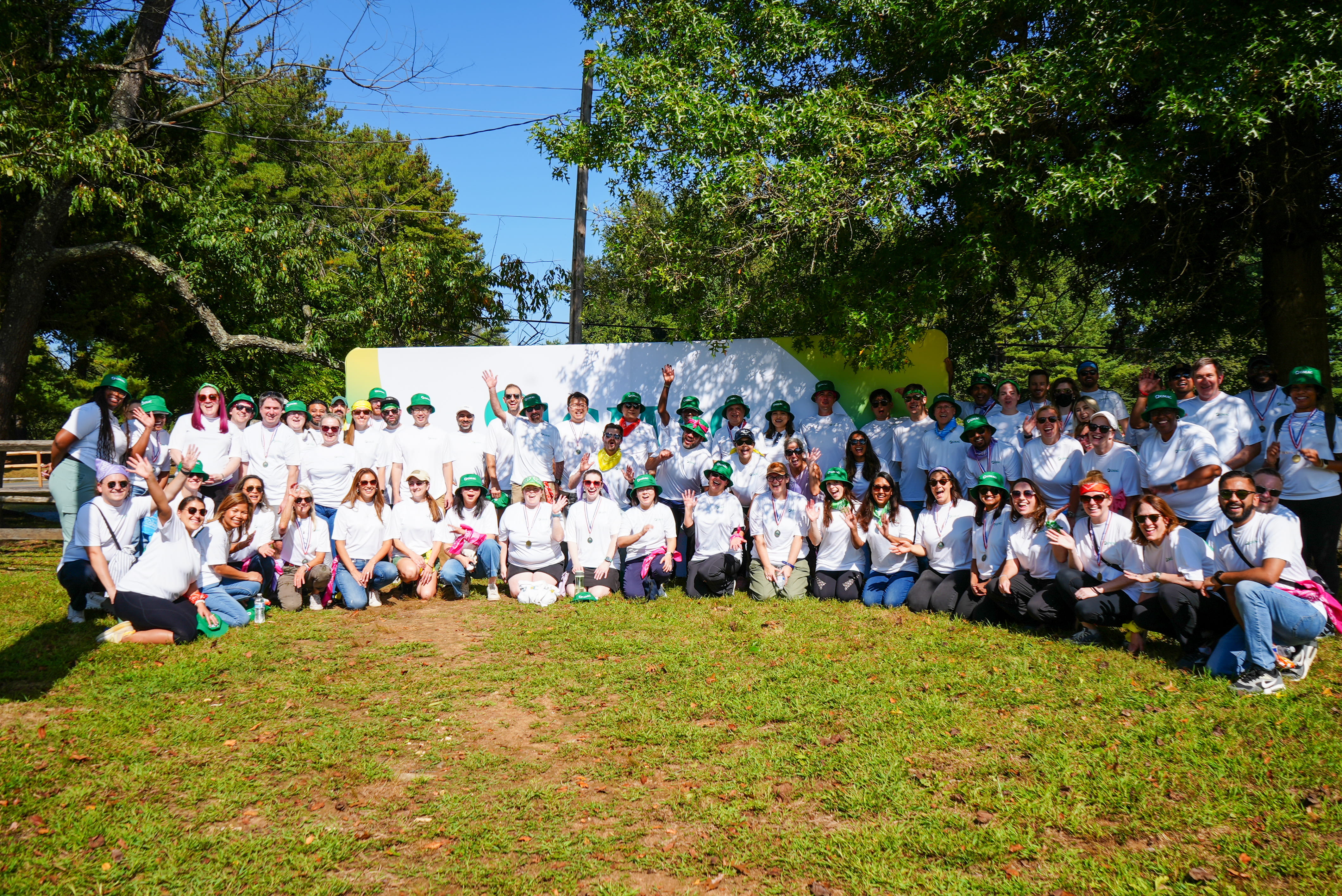 large group of team members in matching shirts posing for photo