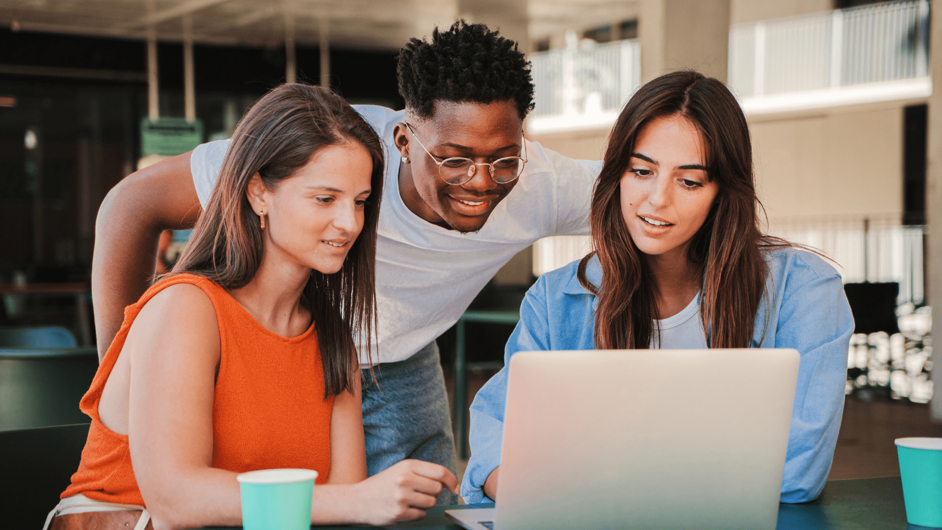 Three students looking at a laptop screen