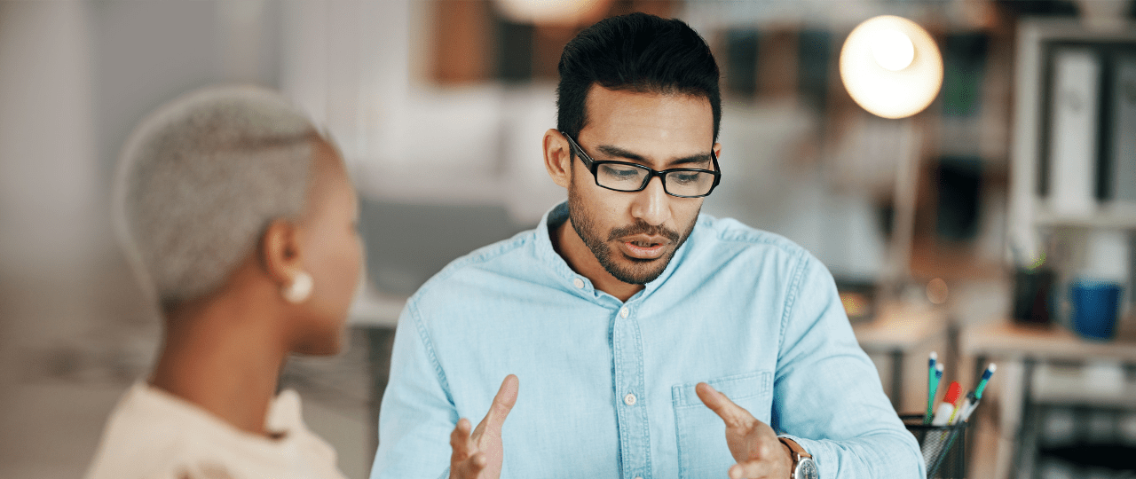 A man and woman sat at a table in conversation