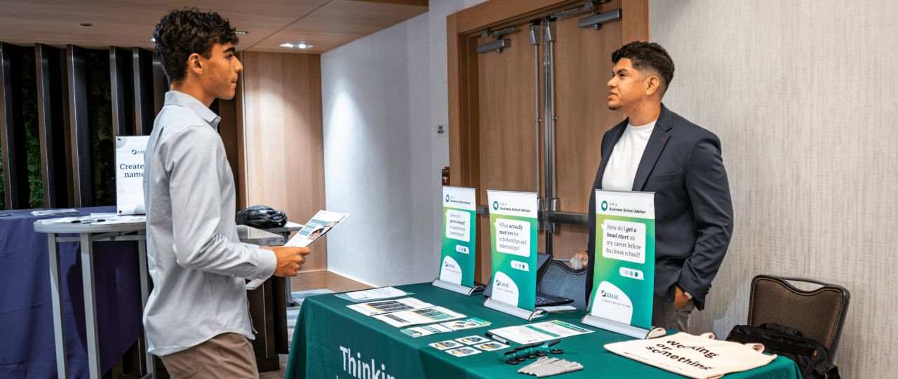 Student talking to a school professional at a recruitment fair