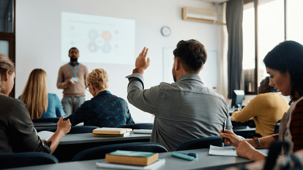 A male student raising his hand in class