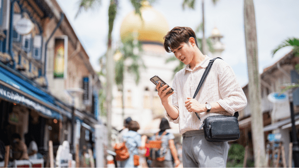 A student on his phone walking down the street