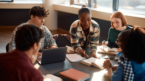 A group of students sat around a table looking at notes together