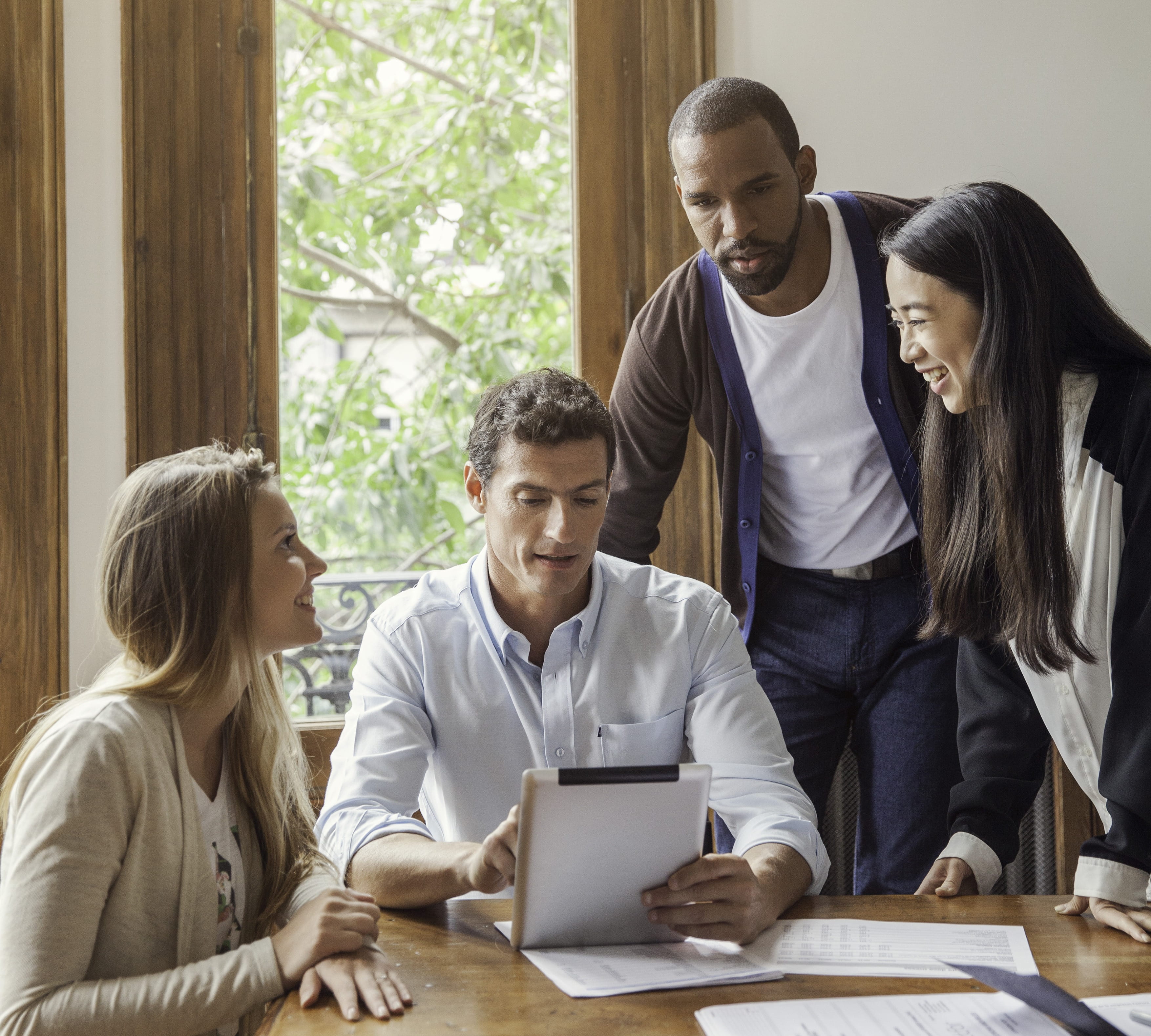 A group of people looking at a tablet together