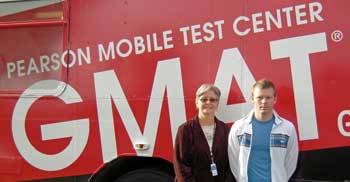 Pearson test administrator Ellen Mazurek, left, welcomes David Minnick, the 1,000th person to take the GMAT exam on the GMAT Mobile Test Center.
