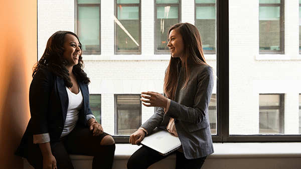 two-woman-sitting-by-window-in-office