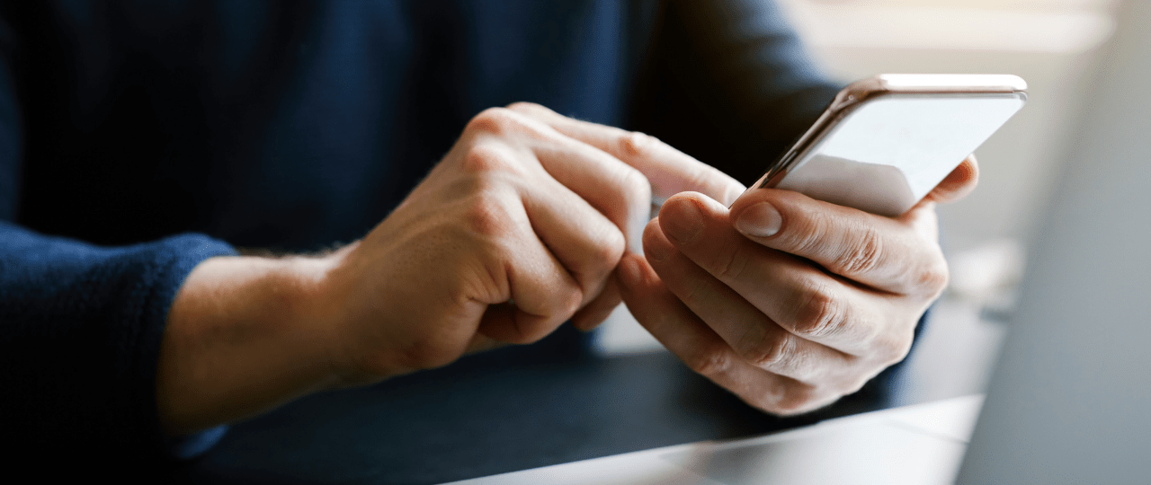 Man holding a smartphone and touching the screen