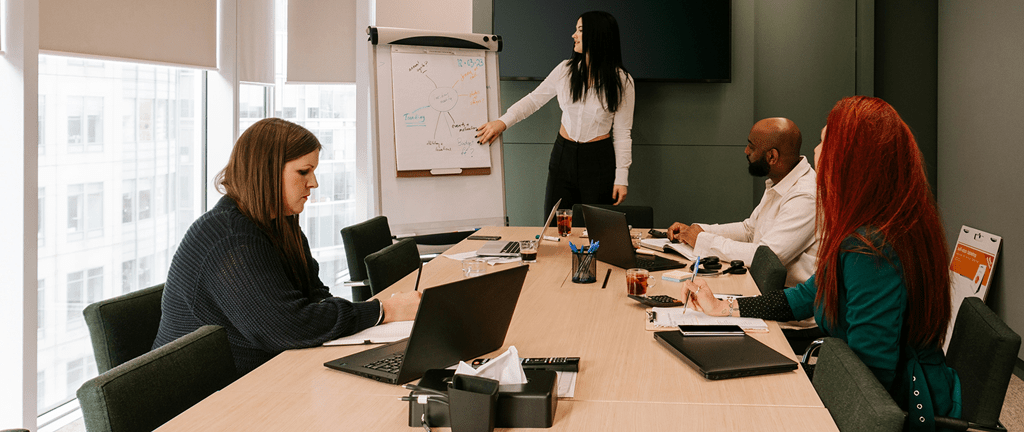group of coworkers whiteboarding in board room setting