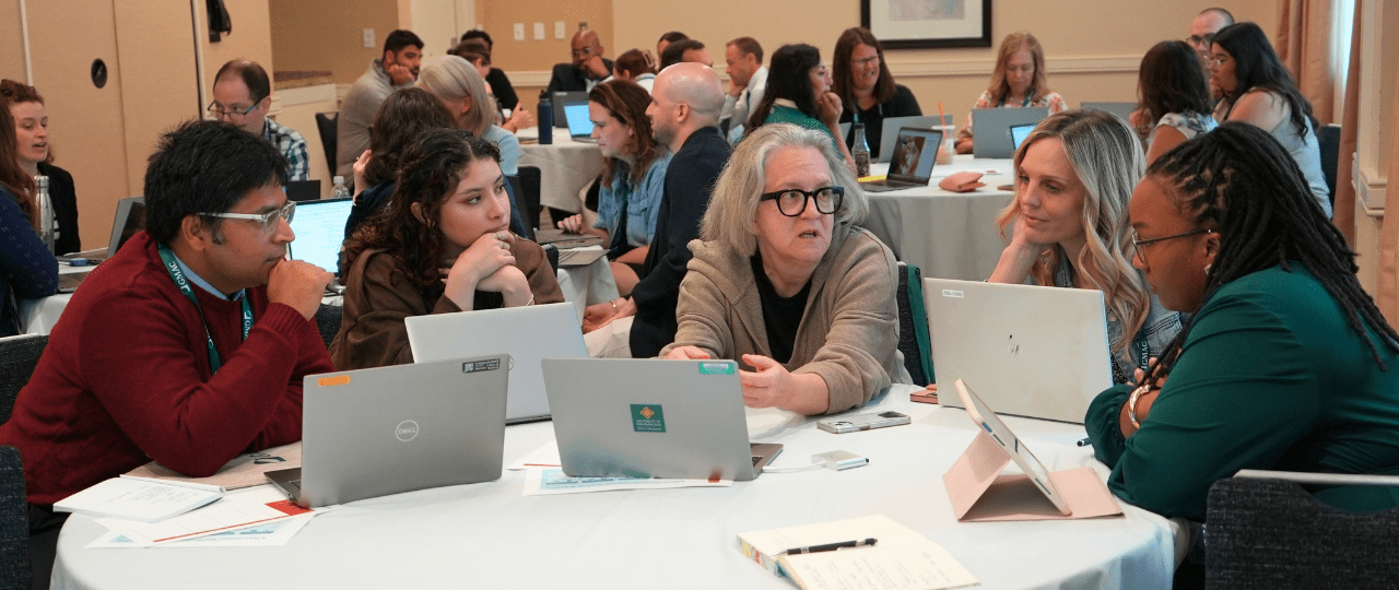 A group of people at a conference sat around a table in discussion