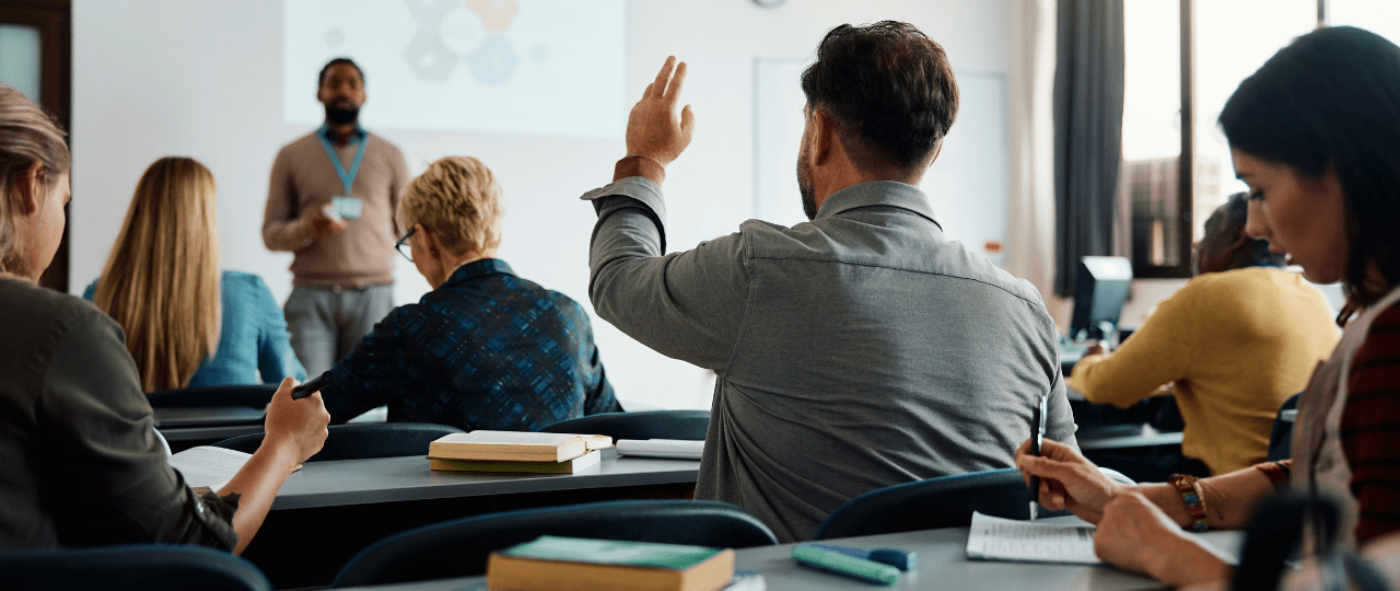 A student raising their hand in a classroom