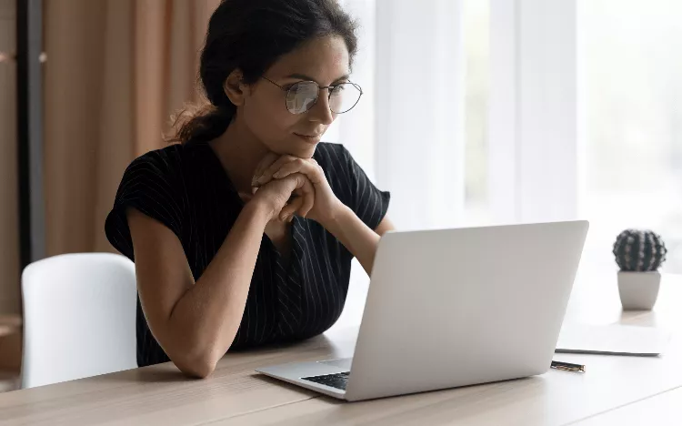 Woman on a computer It takes three minutes to find out your business school application chances iStock