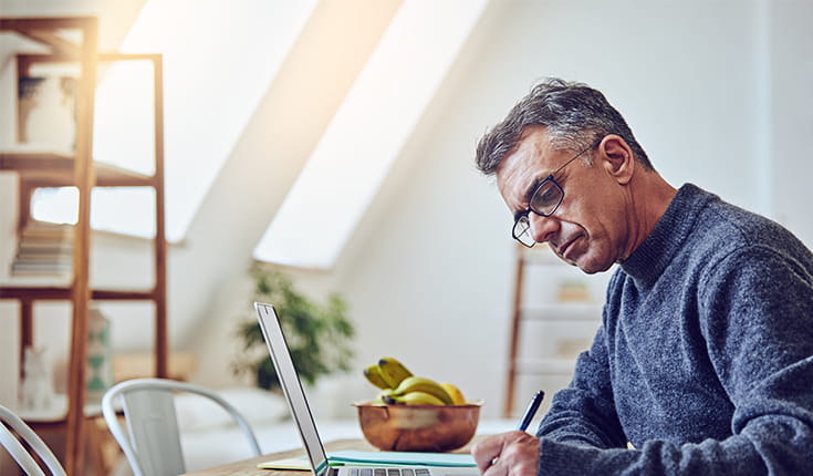 Man in Sweater Writes Longhand 