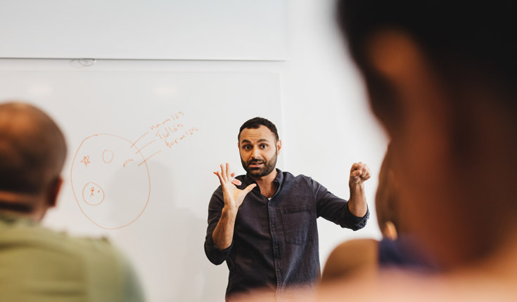 man lecturing at whiteboard