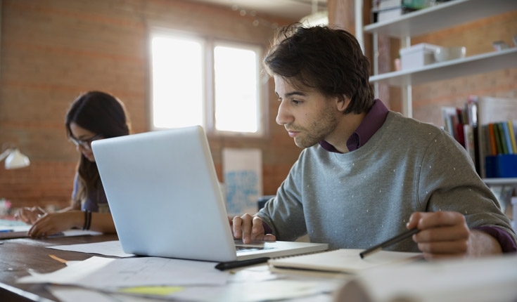 unshaven student with laptop