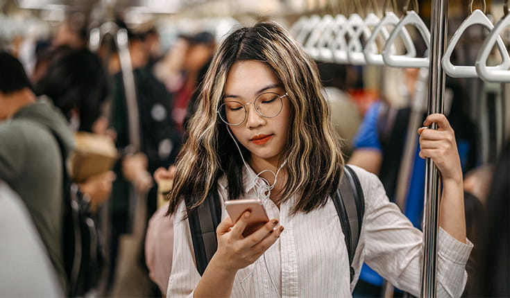 Woman Reads Phone on Subway 