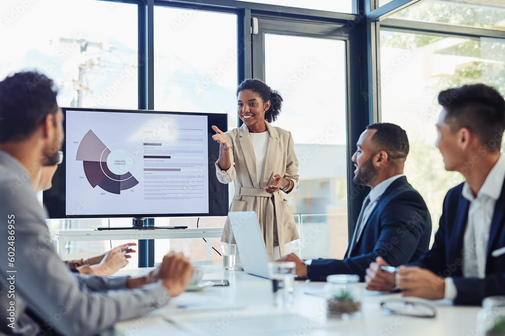 Woman gives presentation in front of a table of professionals