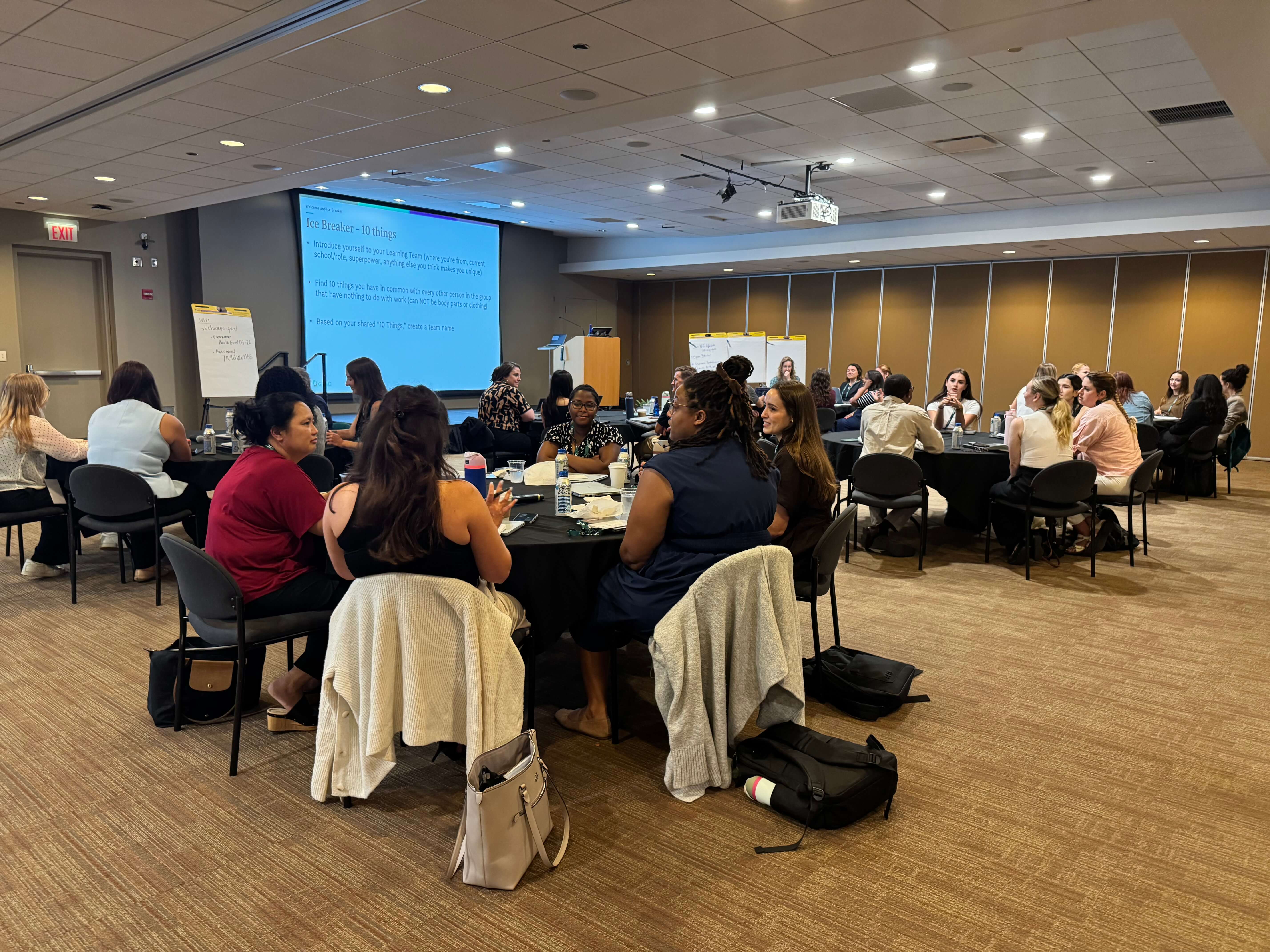 photo of group of attendees at round tables at AINP 2026