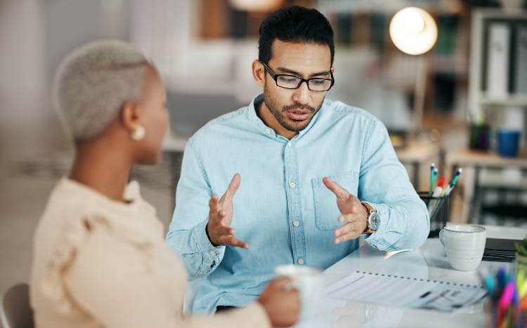 Colleagues having a discussion at a desk